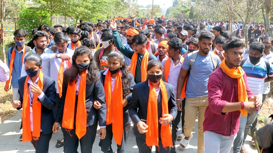 Noticing that some Muslim students attended the classes wearing hijabs, a few students including women staged a protest wearing saffron shawls. Credit: DH Photo