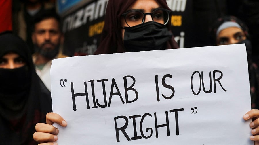 A Muslim woman holds a placard as she takes part in a protest organised by All India Majlis-e-Ittehadul Muslimeen (AIMM) against the recent hijab ban in few colleges of Karnataka state, at Shaheen Bagh in New Delhi. Credit: Reuters Photo