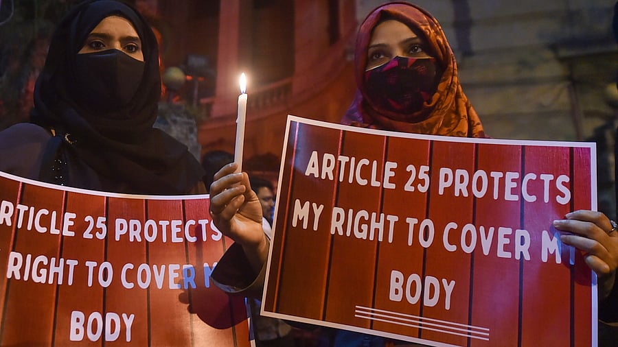 Muslim women holding candles and placards, participate in a candlelight march in protest over the 'hijab' controversy. Credit: PTI Photo
