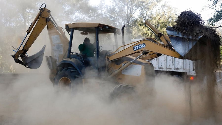 A machine moves debris after a landslide and a fallen tree block a road, following an earthquake that hit southwestern Guatemala, near Antigua. Credit: Reuters photo