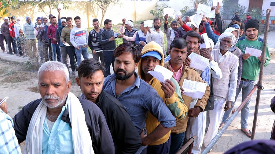 People queue up to cast their vote at a polling booth in Hathras. Credit: PTI Photo