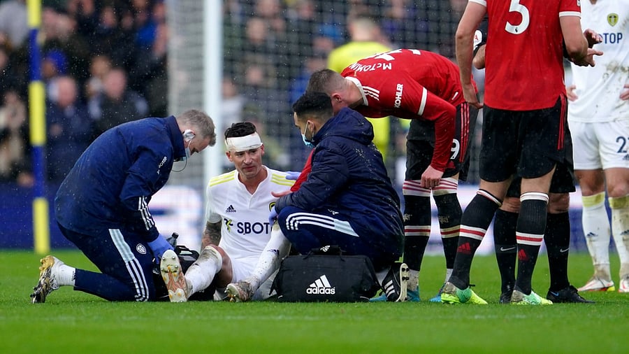 Leeds United's Robin Koch receives medical treatment during the English Premier League soccer match against Manchester United, at Elland Road Stadium in Leeds. Credit: AP/PTI Photo