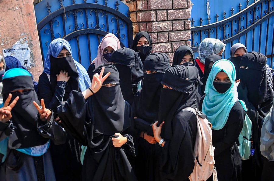 Students stand outside a college as they boycott classes after being denied entry with 'hijab' in the college premises. Credit: PTI Photo