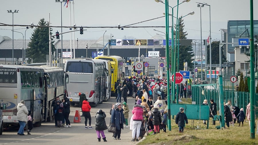 People fleeing the Russian invasion in Ukraine stand in line at the border crossing, waiting for entry into Poland. Credit: Reuters Photo
