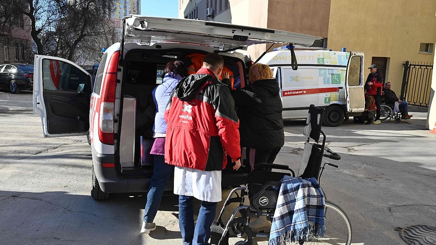Medical personnel evacuate patients from a hospital not far from a high-rise apartment block which was hit by recent shelling in Kyiv. Credit: AFP File Photo