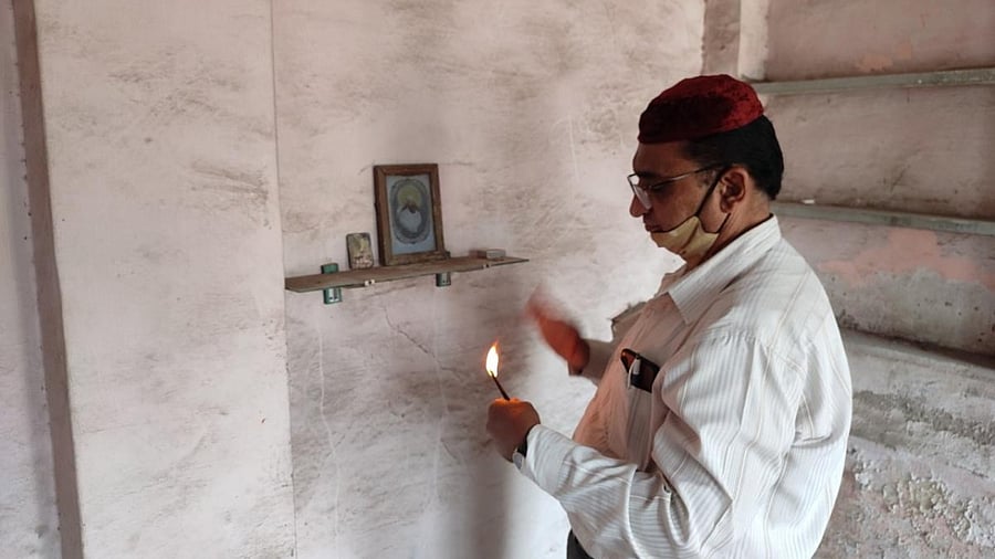 Dara Mody, 59, offering prayers at his abandoned flat at Gulberg Society. Credit: DH photo
