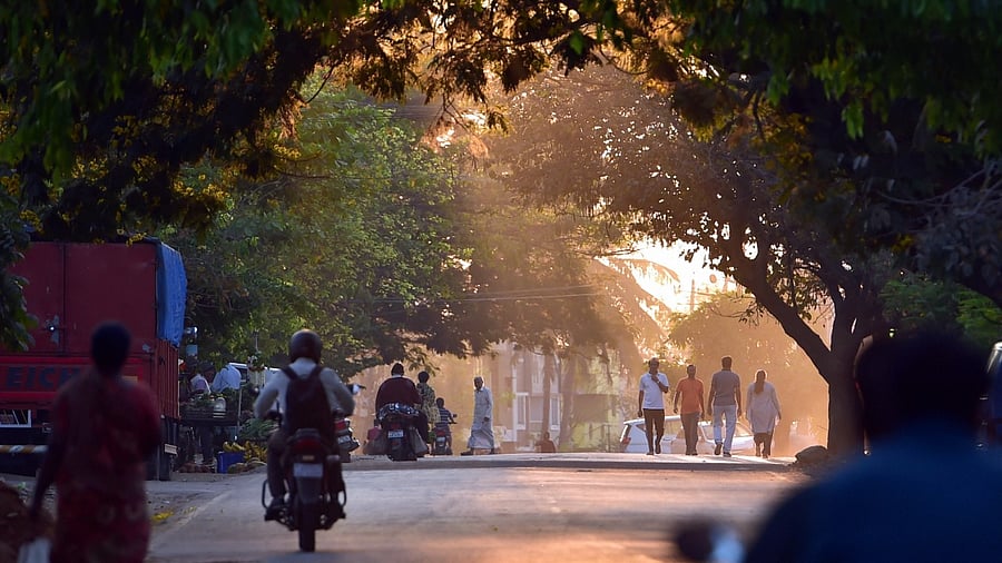 Commuters walk during sunrise after Section 144 was lifted by authorities in Shivamogga, Saturday, Feb. 26, 2022. Credit: PTI Photo