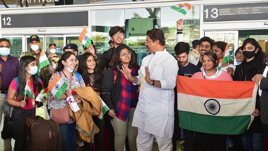 Karnataka Minister R Ashoka (C) welcomes Indian nationals, evacuated from crisis-hit Ukraine, upon their arrival at the airport in Bengaluru, Sunday, Feb 27, 2022. Credit: PTI Photo