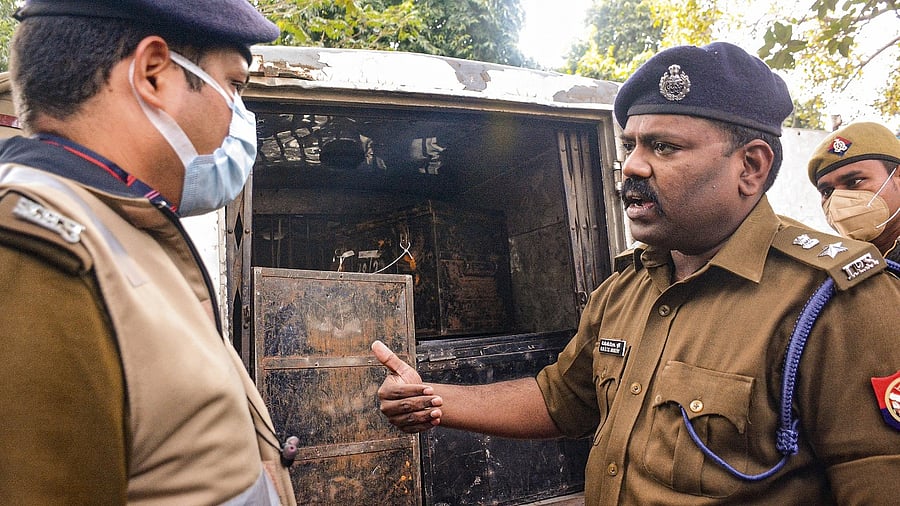 Policemen stand near a vehicle from which they recovered cash during checking ahead of the Uttar Pradesh Assembly elections. Credit: PTI File Photo