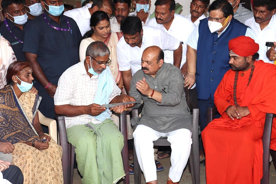 Bommai met the victim’s parents at their house and offered a floral tribute to Naveen’s portrait. Credit: DH Photo