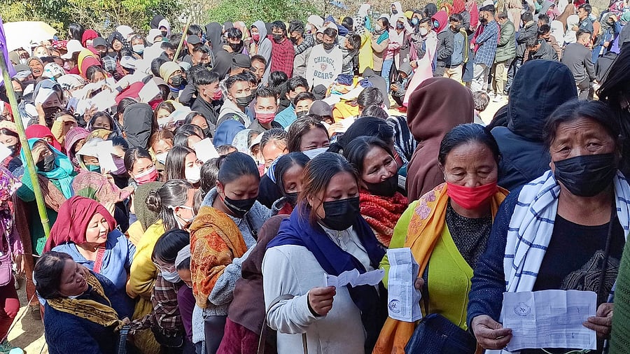 Voters holding their identification cards stand in queues to cast their votes for the second phase of Manipur Assembly elections, in Senapati, Saturday, March 5, 2022. Credit: PTI Photo