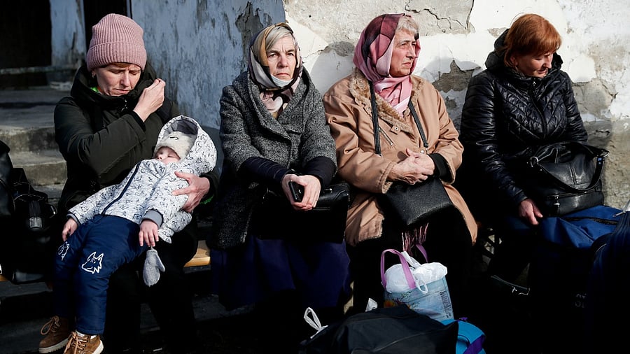 Women fleeing from Ukraine wait near a refugee shelter, after Russia's invasion of Ukraine. Credit: Reuters File Photo