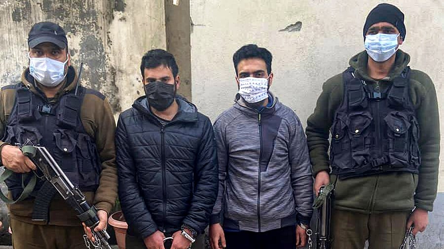 Policemen with two persons accused of throwing grenade at Amira Kadal, after their arrest from Khanyar locality, in Srinagar. Credit: PTI Photo