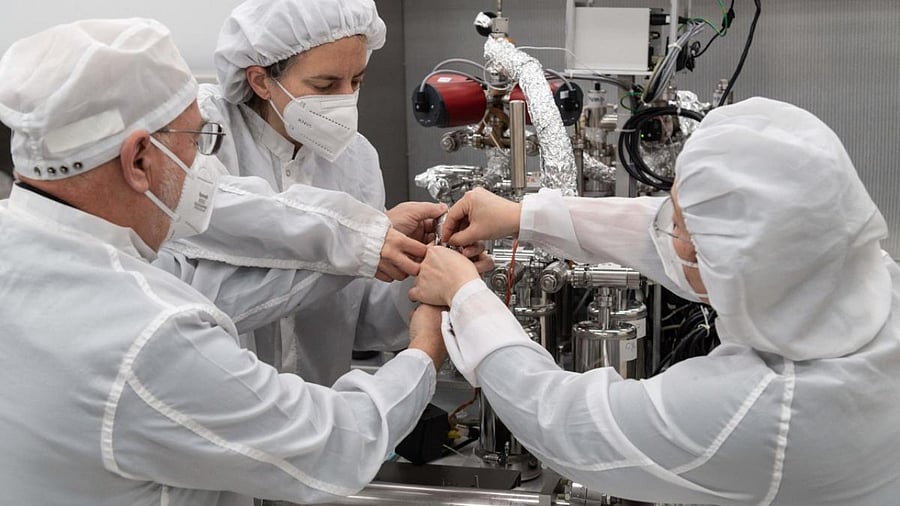 This handout photo released by NASA Shows (from L) Dr. Juliane Gross, Astromaterials Research and Exploration Science Division (ARES) deputy Apollo curator, alongside Drs. Alex Meshik, and Olga Pravdivtseva, from Washington University in St. Louis, beginning a gas extraction process using the manifold (a device to extract and collect the gas) on one of the last unopened, Apollo-era lunar samples. Credit: AFP Photo