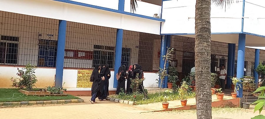 Students stand outside the Government First Grade College at Kaup in Udupi district.