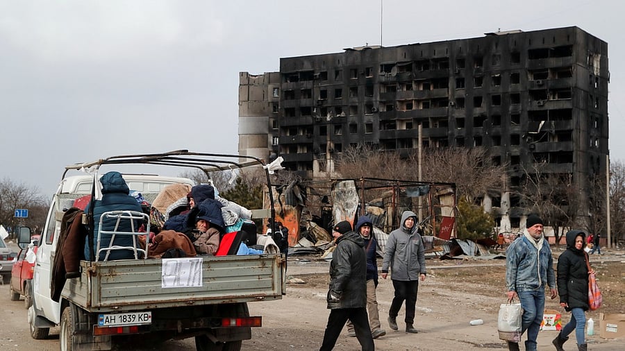 Evacuees fleeing Ukraine-Russia conflict sit in the body of a cargo vehicle while waiting in a line to leave the besieged southern port city of Mariupol, Ukraine. Credit: Reuters Photo