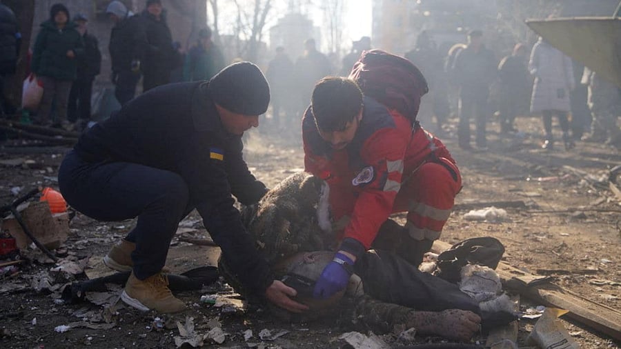 Rescuers help an injured person next to residential buildings damaged by shelling in Kyiv. Credit: Reuters Photo