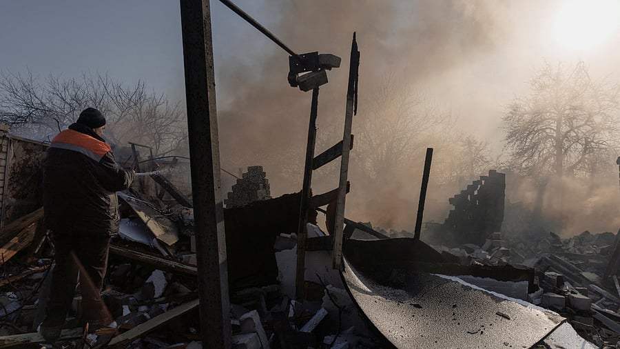 A resident extinguishes a fire after a bombing destroyed a family home in a northern district of Kharkiv as Russia's attack on Ukraine continues. Credit: Reuters Photo