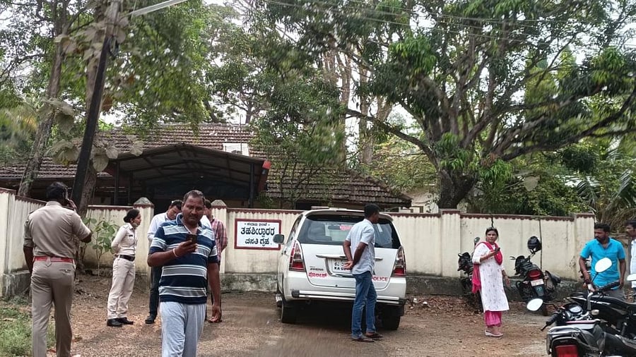 Locals and police gather outside the residence of tahsildar Sridhar Mundalamani at Mundagod on Friday.