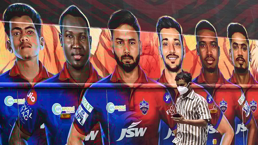 A pedestrian walks past the bus of Indian Premier League's (IPL) Delhi Capitals in Mumbai. Credit: AFP Photo