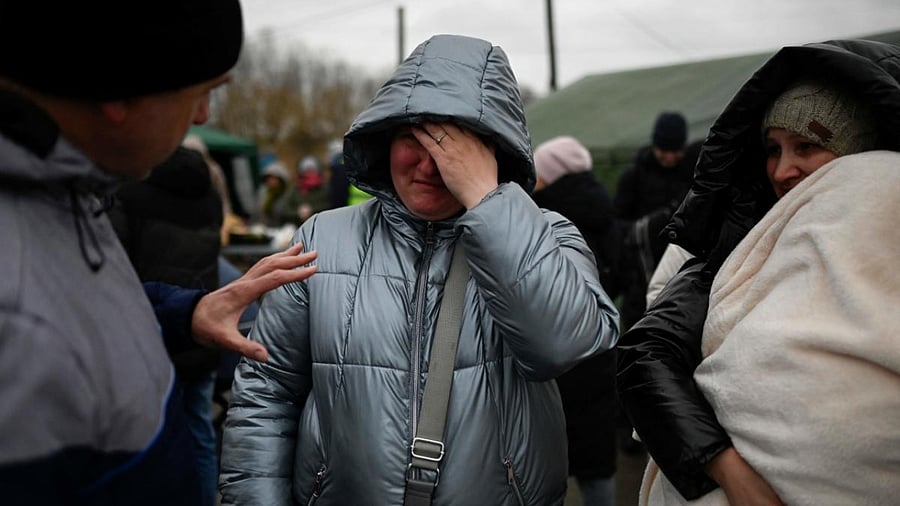 A female Ukrainian refugee cries as she waits for a transport at the Moldova-Ukrainian border's checkpoint near the town of Palanca on March 1, 2022. Credit: AFP Photo