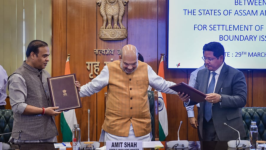 Assam Chief Minister Himanta Biswa Sarma(L) and Meghalaya Chief Minister Conrad K Sangma (R) sign an agreement to resolve the boundary dispute between their states. Credit: PTI Photo