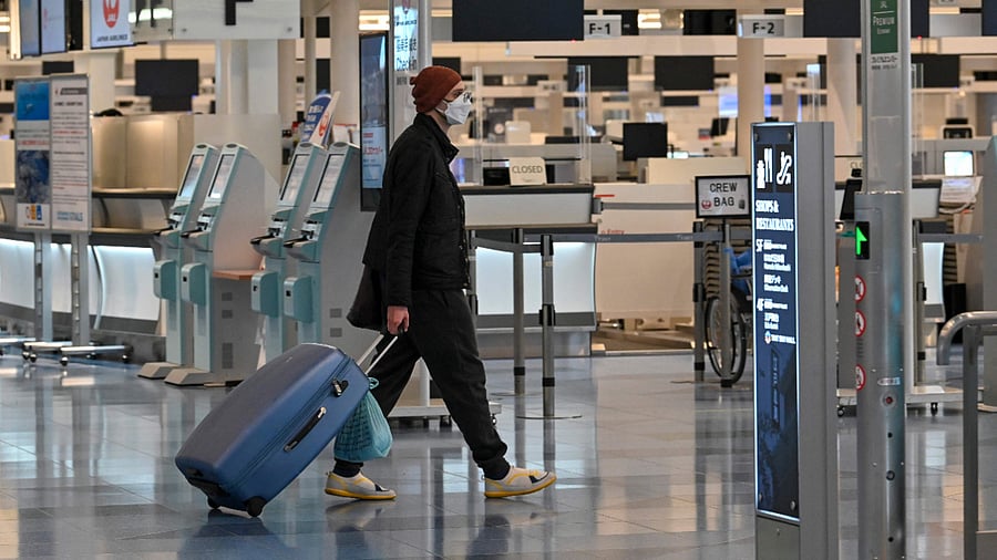 A man walks past check-in counters at an international flight departure floor at Tokyo's Haneda airport. Credit: AFP Photo