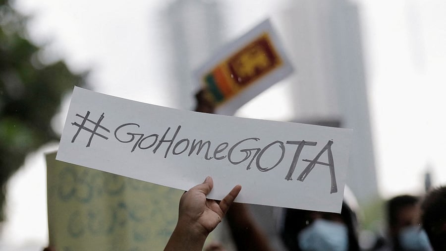 A person holds a placard demanding Sri Lanka's President Rajapaksa to resign during a protest in Colombo. Credit: Reuters Photo