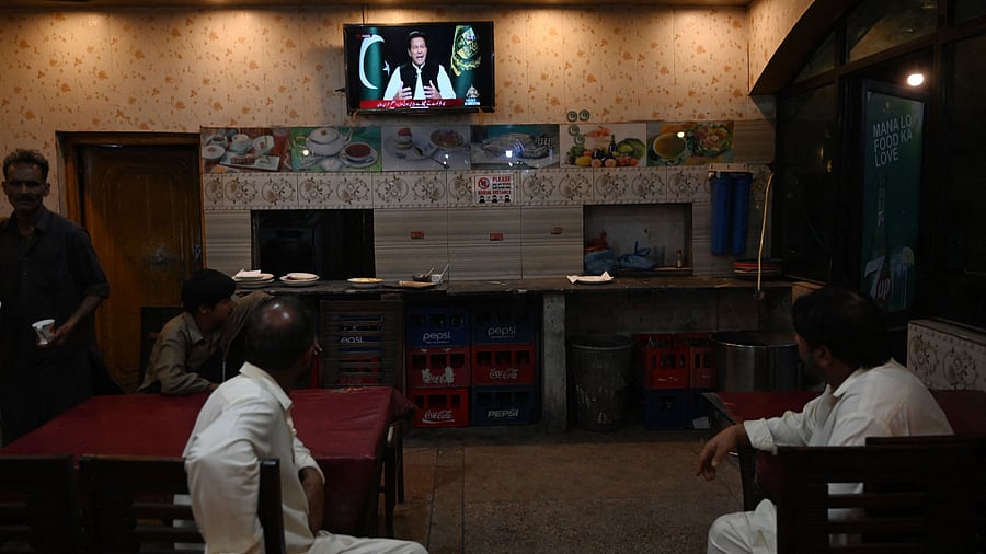 People listen to Pakistan's Prime Minister Imran Khan addressing the nation. Credit: AFP Photo