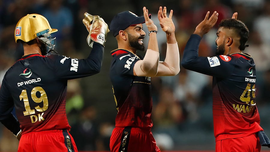 Wanindu Hasaranga of Royal Challengers Bangalore celebrates with teammate Virat Kohli after the wicket of Dewald Brevis of Mumbai Indians. Credit: PTI Photo