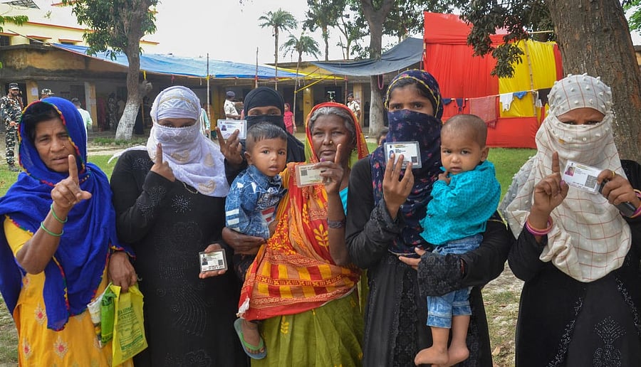 Voters show their identification cards and inked fingers after casting their votes for the Bochaha Assembly by-polls, in Muzaffarpur. Credit: PTI