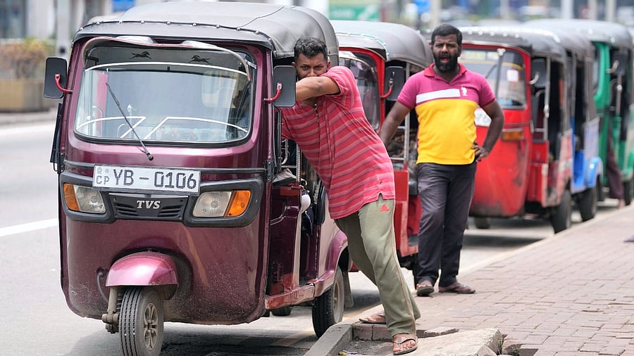 Sri Lankan auto rickshaw drivers queue up to buy petrol near a fuel station in Colombo. Credit: AP/PTI Photo