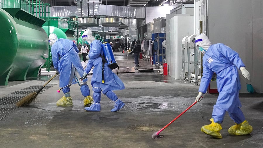 Workers clean and disinfect the floor of a makeshift hospital at the National Exhibition and Convention Center in Shanghai. Credit: AP Photo
