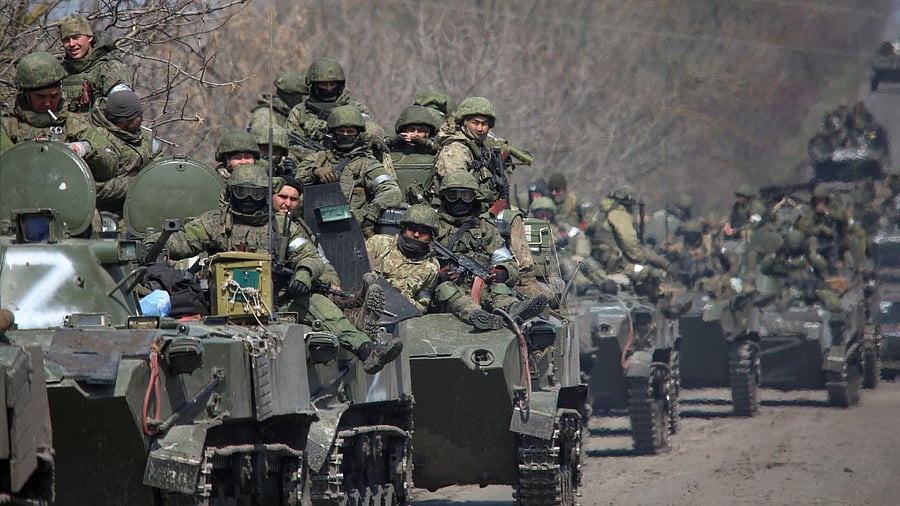 Service members of pro-Russian troops ride on armoured vehicles in the course of Ukraine-Russia conflict on a road leading to the city of Mariupol. Credit: Reuters Photo