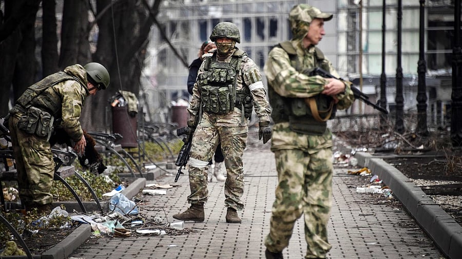 Russian soldiers walks along a street in Mariupol on April 12, 2022, as Russian troops intensify a campaign to take the strategic port city. Credit: AFP Photo
