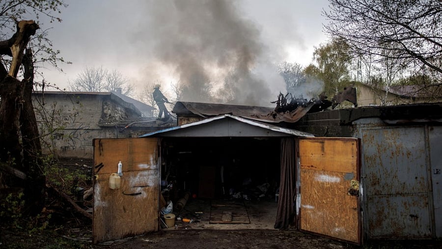A firefighter tries to extinguish a fire burning at a garage, following Russian shelling, amid Russia's attack on Ukraine, in Kharkiv. Credit: Reuters photo