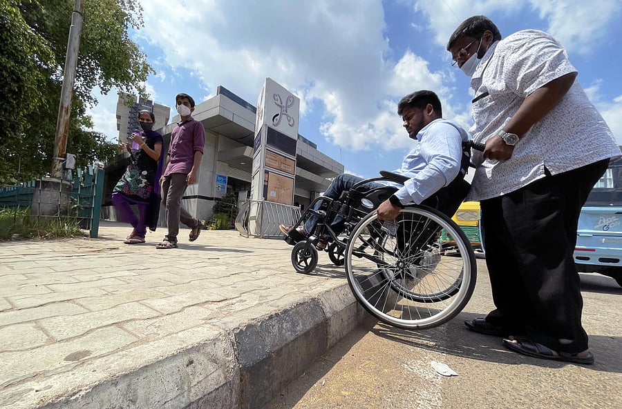 As his father and the driver got down to re-assemble his wheelchair, Imran scanned the premises for a ramp or lift to get inside. He spotted neither. Credit: DH Photo/Pushkar V
