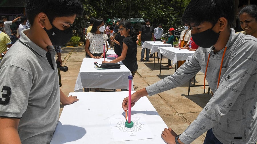 A student explains his exhibit to a visitor at the Jawaharlal Nehru Planetarium in Bengaluru on Sunday. Credit: DH Photo/B H Shivakumar