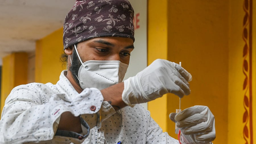 A health worker collects a swab sample for an RT-PCR test. Credit: DH Photo