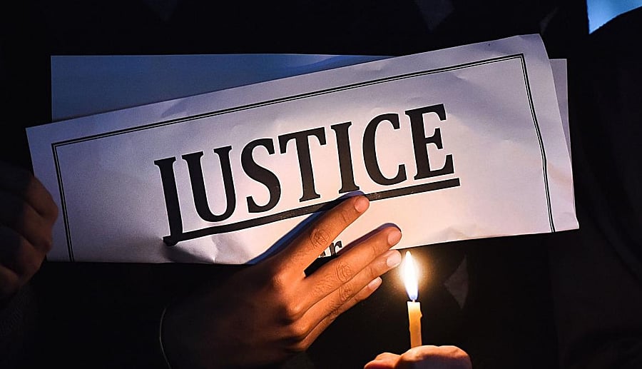 <div class="paragraphs"><p>People light candles and display placards during a protest against rape. </p></div>