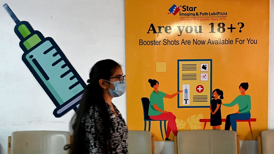 A girl walks past a poster at a vaccination centre in New Delhi. Credit: AFP Photo