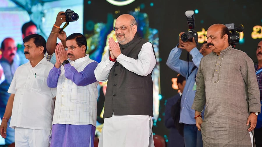 Union Home Minister Amit Shah with Union Parliamentary Affairs Minister Pralhad Joshi and Karnataka Chief Minister Basavaraj Bommai, during the inauguration of the Nrupathunga University, logo unveiling and foundation stone laying ceremony, in Bengaluru. Credit: PTI Photo