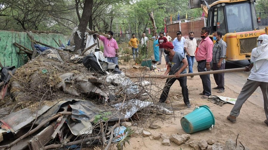A JCB excavator being used to remove illegal structure during an anti-encroachment drive by South Delhi Municipal Corporation at Karni Singh Shooting Range area of Tughlakabad in New Delhi. Credit: IANS Photo