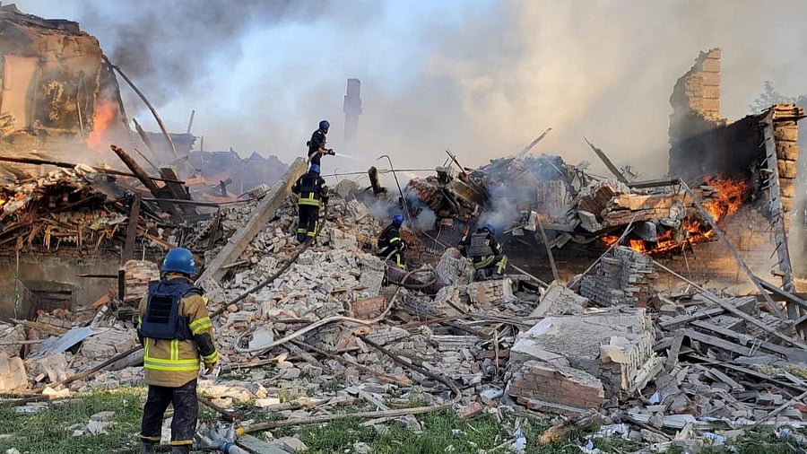 Emergency crew tend to a fire near a burning debris, after a school building was hit as a result of shelling, in the village of Bilohorivka. Credit: Reuters Photo