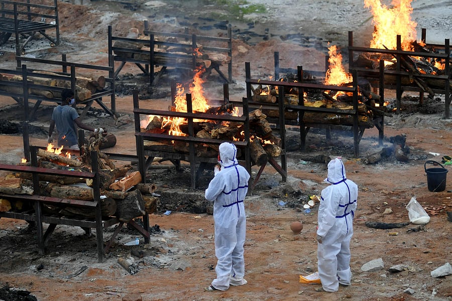 Family members cremate their loved ones at Giddenahalli open cremation set up in the outskirts of Bengaluru on Sunday, May 02, 2021. Credit: DH Photo