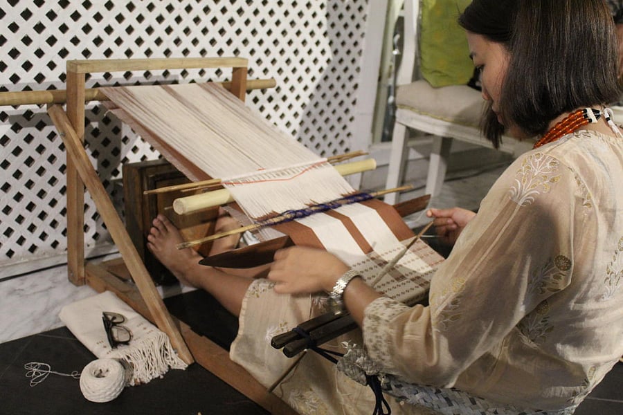 Lovitoli working on her traditional Naga loin loom. The technique is commonly called back-strap weaving. Credit: DH Photo