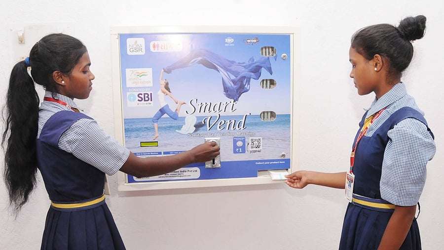 Students of Snehkul Public High School use a vending machine to collect sanitary pads at Balsiring village, in Ranchi. Credit: PTI Photo