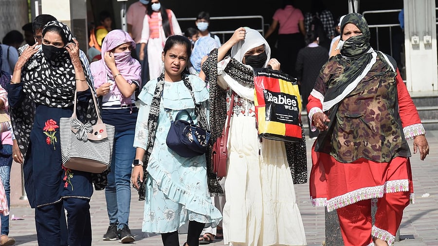 Women use scarves to shield themselves from the heat on a hot summer afternoon. Credit: PTI Photo