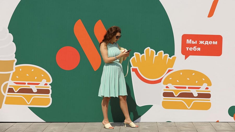 A woman stands next to a banner before the opening of the new restaurant "Vkusno & tochka" following McDonald's Corp company's exit from the Russian market in Moscow. Credit: Reuters photo