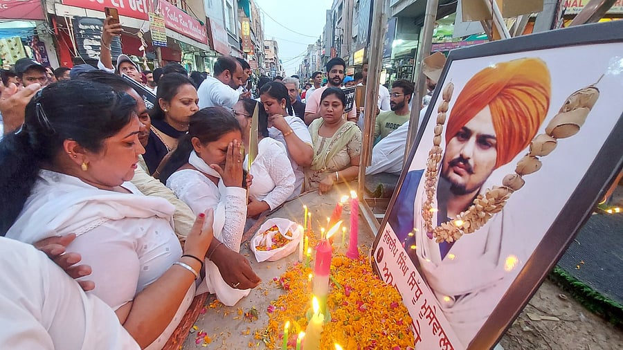 Workers light candles and pay floral tribute to late Punjabi singer and Congress leader Sidhu Moosewala. Credit: PTI Photo